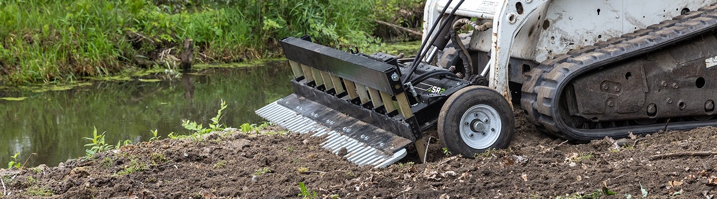 ABI Attachments SR2 working with soil close to a water's edge