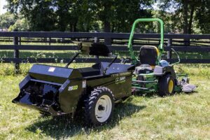 ABI Attachments 25 Cubic Foot Ground Drive Manure Spreader attached to a riding lawnmower