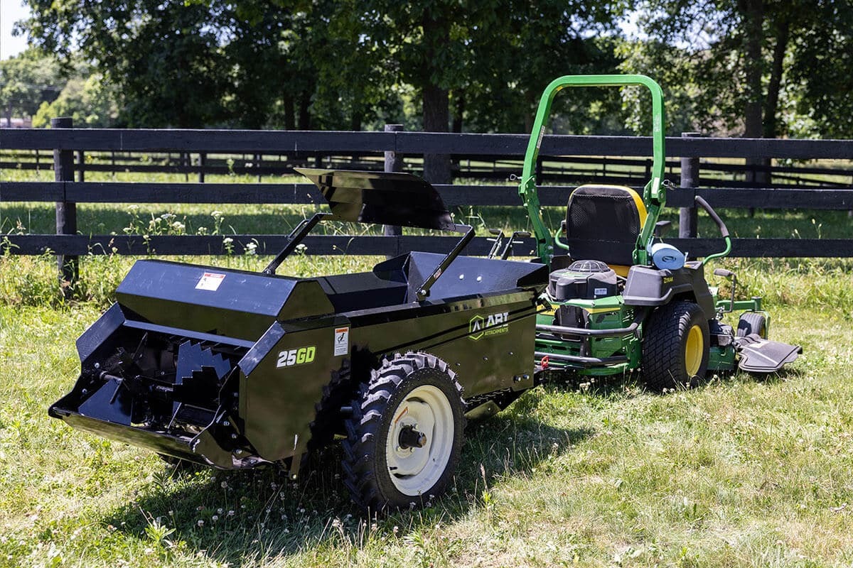 ABI Attachments 25 Cubic Foot Ground Drive Manure Spreader attached to a riding lawnmower