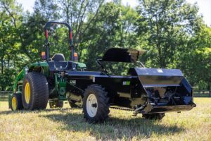 ABI Attachments 65 Cubic Foot Ground Drive Manure Spreader attached to a compact tractor