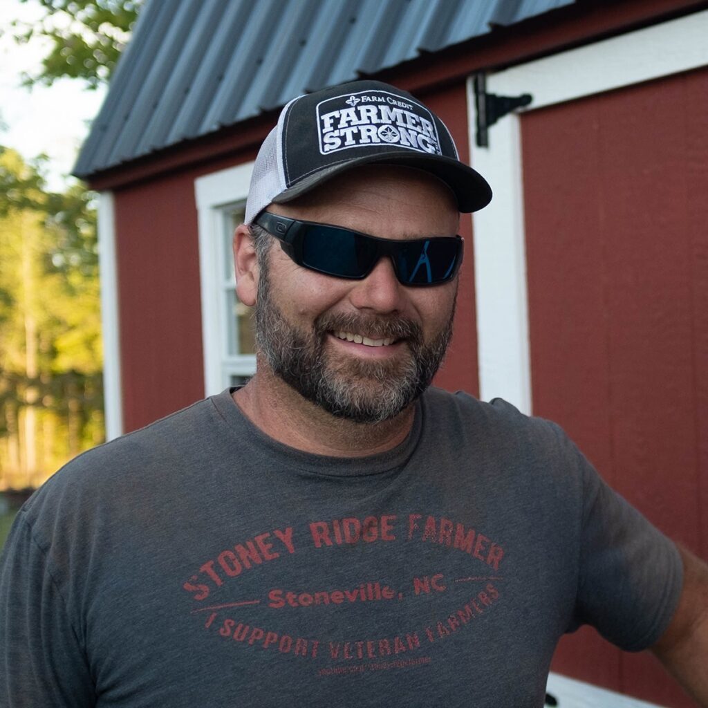 Man smiling with a hat saying, 'Farmer Strong'.