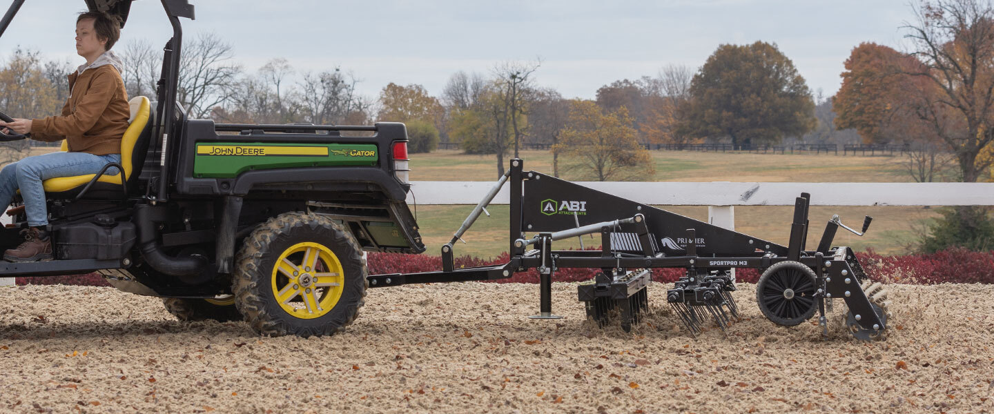 ABI Attachments SportPro M3 grooming an outdoor synthetic footing arena