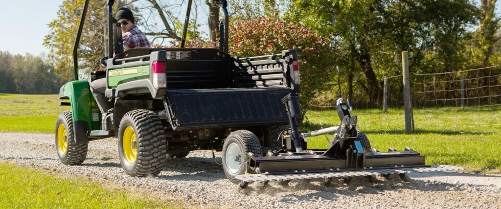 ABI Attachments Gravel Rascal Pro using scarifiers on a gravel pathway