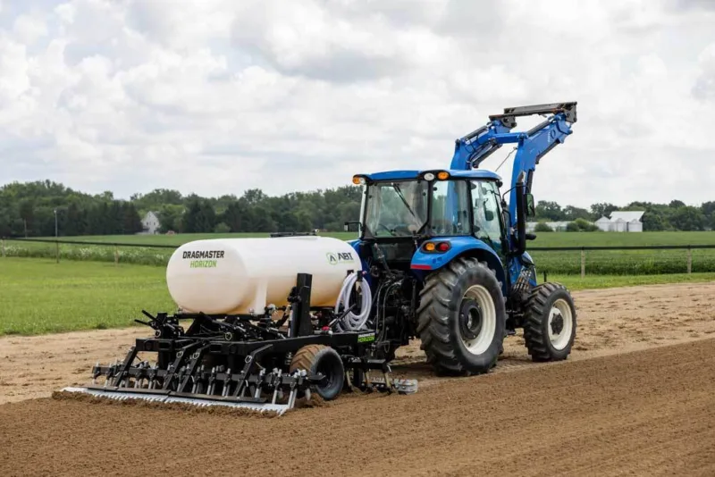 Dragmaster Horizon in use on soil, while attached to a blue tractor.