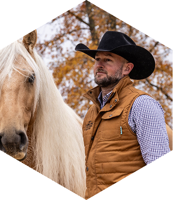 Dan James on a horse, looking off to the side.