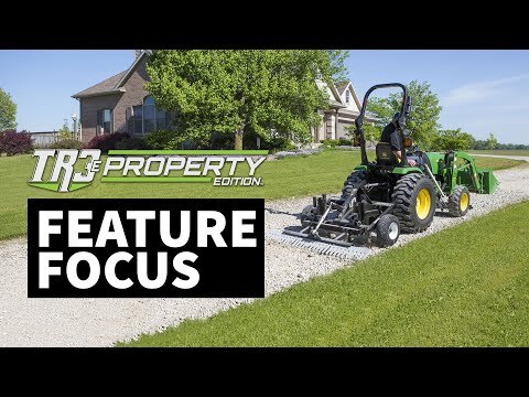 The words ‘TR3e Property Edition – Feature Focus+’ appear in bold white font. The background shows a house and trees, with the TR3e Property Edition displayed behind a tractor.