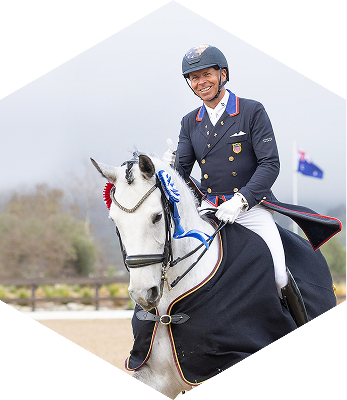 ABI Pros Ambassador Hex - Steffen Peters - He is riding a horse and is nicely dressed.