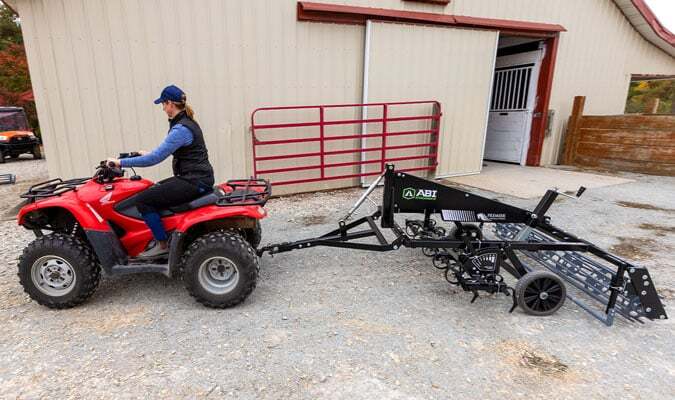 Red UTV dragging a Sportpro M1.