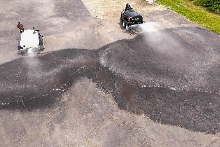 ABI 550 DOT Pro Water Trailer with a black water tank spraying a larger area than another water trailer
