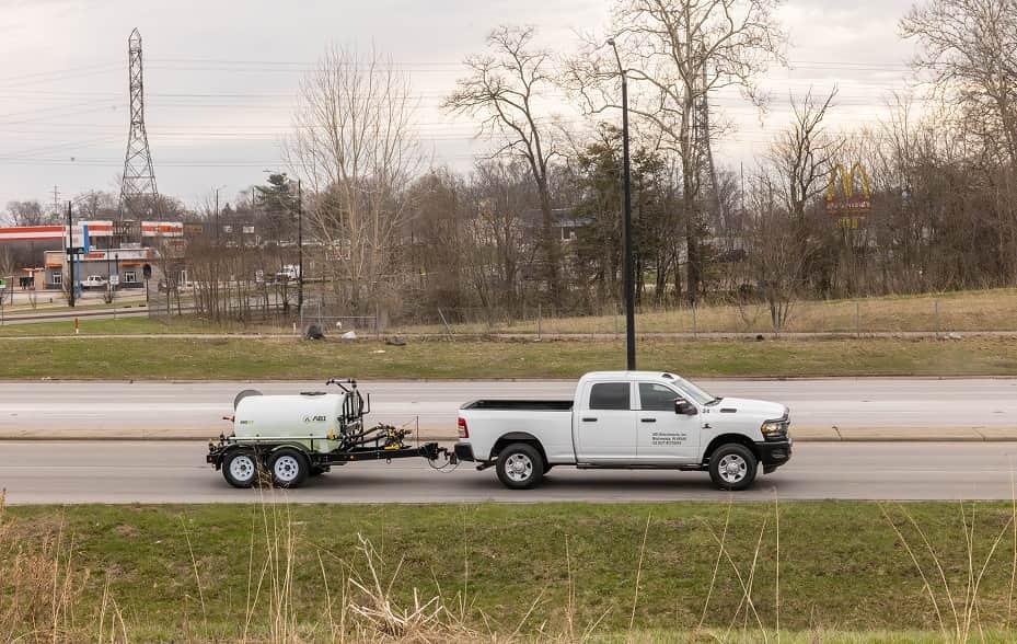 ABI 550 DOT Pro Water Trailer being towed by a pickup truck on a public road